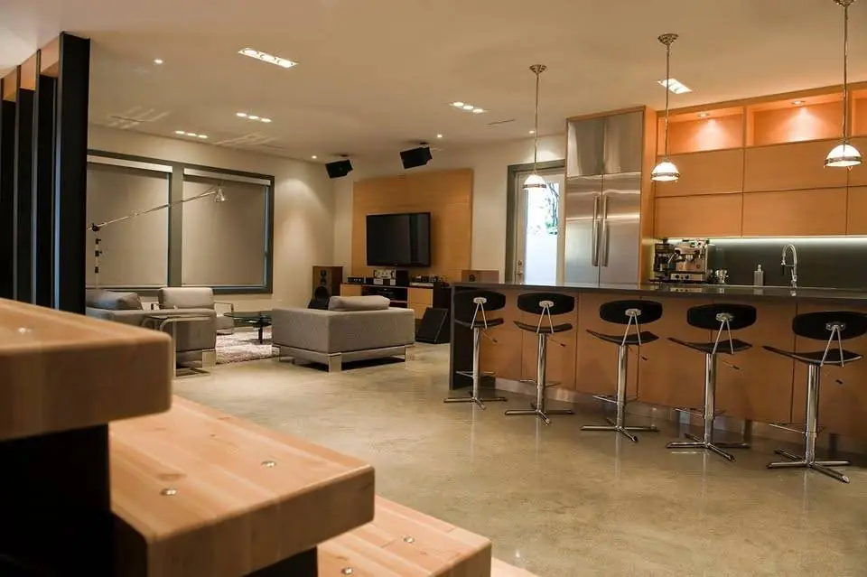 Open-plan living space with custom wood kitchen cabinetry and bar seating